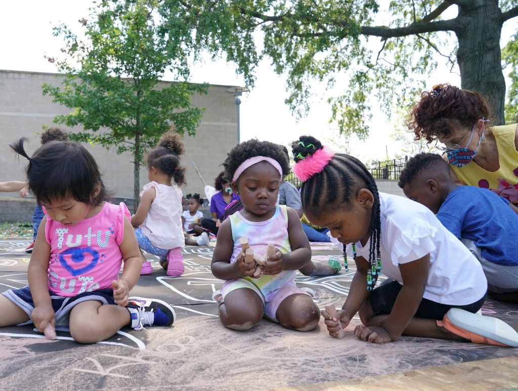 Children and teachers from the KU Kids Deanwood Child Care Center complete a mural.